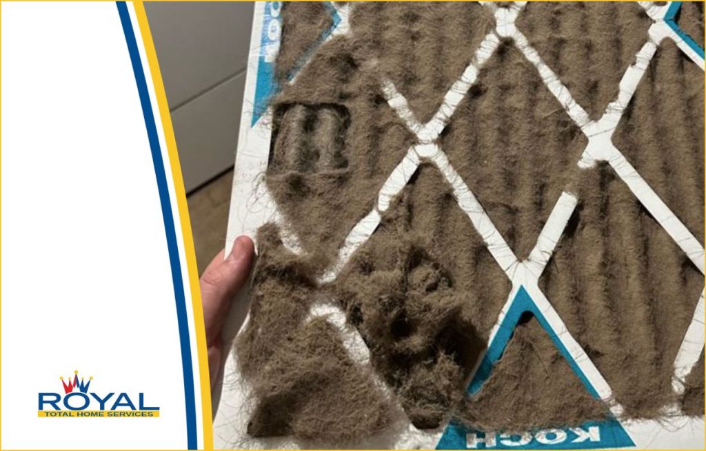 A royal HVAC technician changing a dirty air filter
