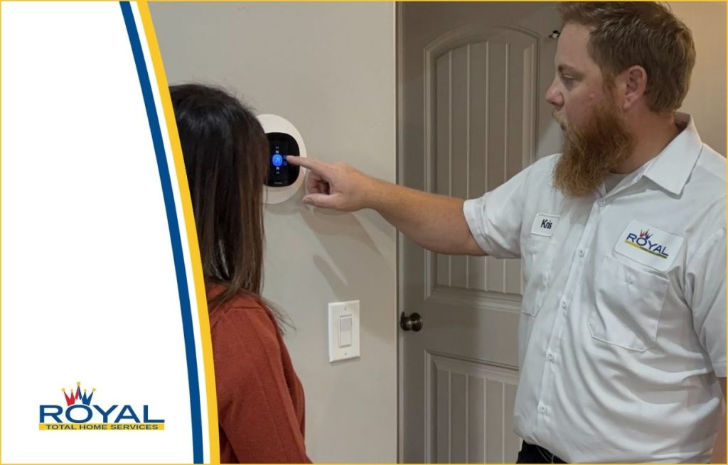 A royal HVAC technician showing a homeowner her new smart thermostat.