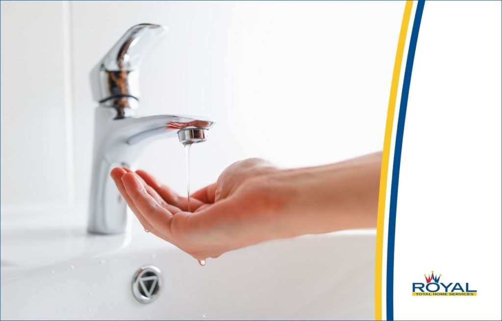A hand under a low water pressure faucet.