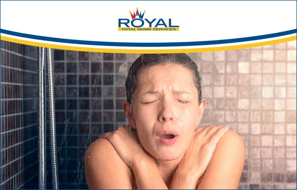 A woman experiencing the hot water running out of the shower.